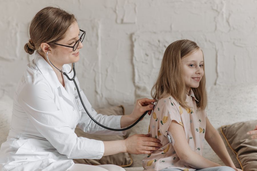 A friendly doctor checking a young girl during a health check-up