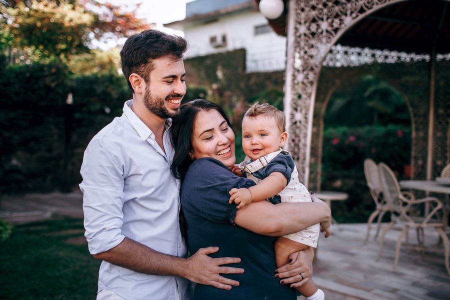 Smiling parents holding their baby in a garden